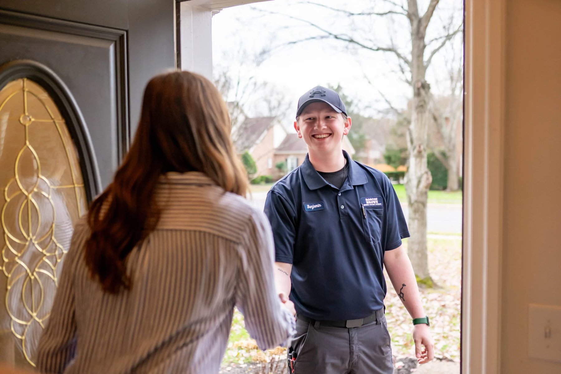 Professional home-service technician greeting a homeowner at the door